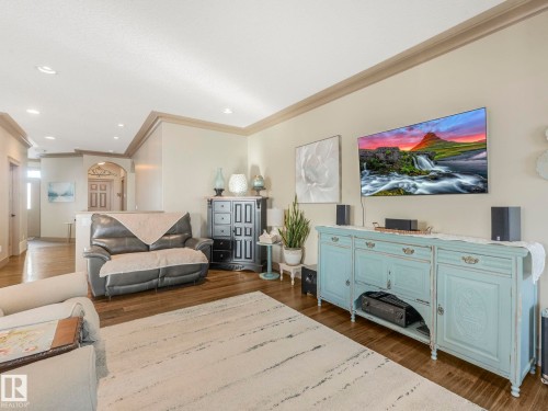 Living room featuring dark wood-style floors, crown molding, and recessed lighting - 117 Mcdowell Wynd, Leduc, AB - Indoor Photo Showing Other Room