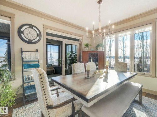 Dining space with dark wood-type flooring, a chandelier, and crown molding - 117 Mcdowell Wynd, Leduc, AB - Indoor Photo Showing Dining Room