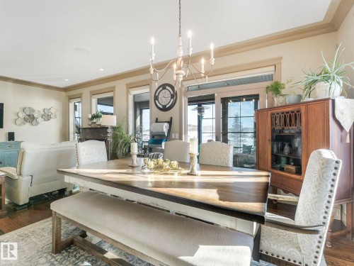 Dining area featuring wood finished floors, ornamental molding, and suspended lighting - 117 Mcdowell Wynd, Leduc, AB - Indoor With Fireplace
