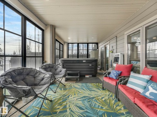Sunroom with an outdoor living space, a jacuzzi, healthy amount of natural light, and heating unit - 117 Mcdowell Wynd, Leduc, AB -  With Deck Patio Veranda With Exterior