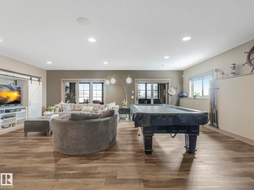 Recreation room featuring a barn door, wood finished floors, pool table, and recessed lighting - 117 Mcdowell Wynd, Leduc, AB - Indoor