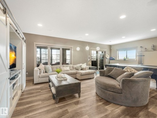 Living area featuring wood finished floors, a barn door, and recessed lighting - 117 Mcdowell Wynd, Leduc, AB - Indoor Photo Showing Living Room