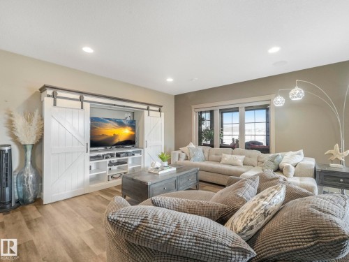 Living room featuring a barn door, wood finished floors, and recessed lighting - 117 Mcdowell Wynd, Leduc, AB - Indoor Photo Showing Living Room