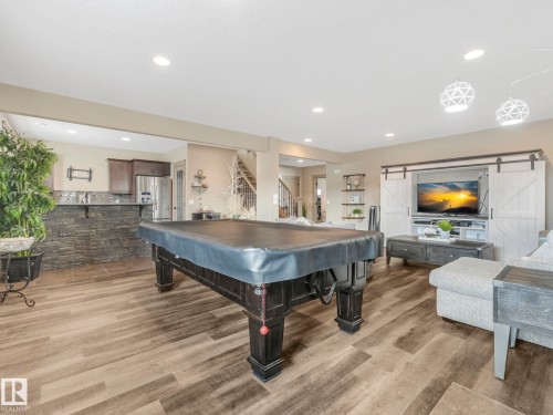 Recreation room with billiards, a barn door, light wood-style floors, and recessed lighting - 117 Mcdowell Wynd, Leduc, AB - Indoor Photo Showing Other Room