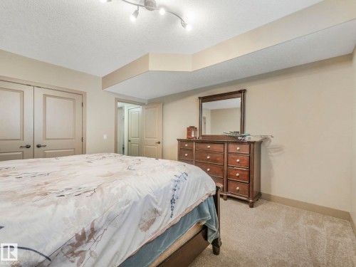 Bedroom with a textured ceiling, light colored carpet, and a closet - 117 Mcdowell Wynd, Leduc, AB - Indoor Photo Showing Bedroom