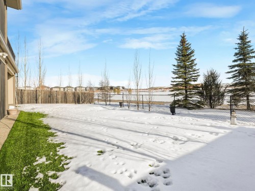 Yard covered in snow featuring a fenced backyard and a residential view - 117 Mcdowell Wynd, Leduc, AB - Outdoor