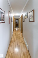 Hallway with crown molding and light wood-style flooring - 