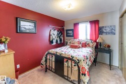 Bedroom featuring light carpet, a textured ceiling, and a closet - 