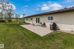 Expansive green lawn with a large concrete patio - 