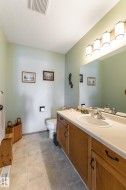 Half bath with vanity, a textured ceiling, and light tile patterned floors - 