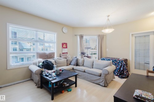 Living area with light wood-style floors and baseboards - 207 9910 111 Street, Edmonton, AB - Indoor Photo Showing Living Room