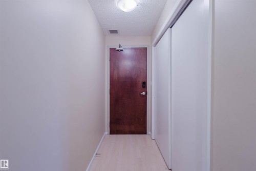 Hall featuring a textured ceiling and light wood finished floors - 207 9910 111 Street, Edmonton, AB - Indoor Photo Showing Other Room