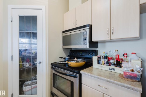 Kitchen featuring stainless steel appliances and light stone countertops - 207 9910 111 Street, Edmonton, AB - Indoor Photo Showing Kitchen