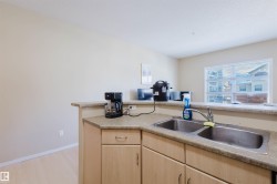Kitchen featuring light wood finish cabinets, light countertops, and light wood-style flooring - 