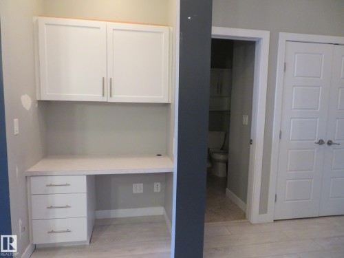 Unfurnished office with built in study area and light wood finished floors - 415 2590 Anderson Way, Edmonton, AB - Indoor Photo Showing Other Room