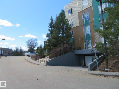Multi-story building featuring varied facade materials including horizontal siding, vertical paneling, and stone accents - 415 2590 Anderson Way, Edmonton, AB - Outdoor