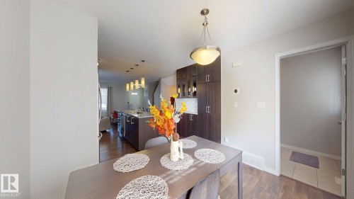 Dining area featuring dark wood-type flooring and a textured ceiling - 1275 Chappelle Boulevard, Edmonton, AB - Indoor Photo Showing Dining Room