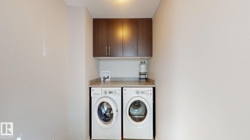 Laundry area with cabinet space, washing machine and clothes dryer, and a textured ceiling - 1275 Chappelle Boulevard, Edmonton, AB - Indoor Photo Showing Laundry Room