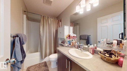 Bathroom featuring a vanity with a countertop, an undermount sink, and a large mirror - 1275 Chappelle Boulevard, Edmonton, AB - Indoor Photo Showing Bathroom
