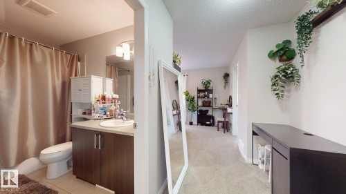 Bathroom featuring a vanity with a white sink, dark wood cabinetry, and a shower with a beige shower curtain - 1275 Chappelle Boulevard, Edmonton, AB - Indoor Photo Showing Bathroom