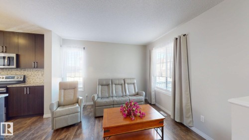Living room with dark wood-type flooring and a textured ceiling - 1275 Chappelle Boulevard, Edmonton, AB - Indoor Photo Showing Kitchen