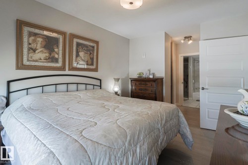 Bedroom with wood finished floors and ensuite bath - 910 2755 109 Street, Edmonton, AB - Indoor Photo Showing Bedroom