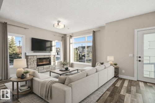 Virtually staged living room - 10 804 Welsh Drive, Edmonton, AB - Indoor Photo Showing Living Room With Fireplace