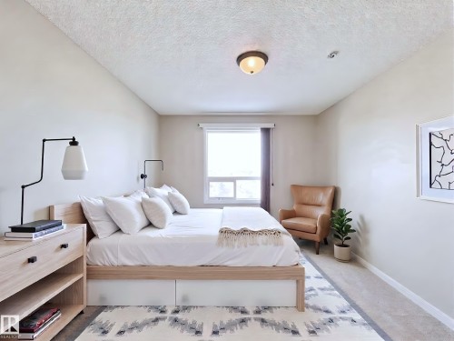 Carpeted bedroom featuring baseboards and a textured ceiling - 3308 9351 Simpson Drive, Edmonton, AB - Indoor Photo Showing Bedroom