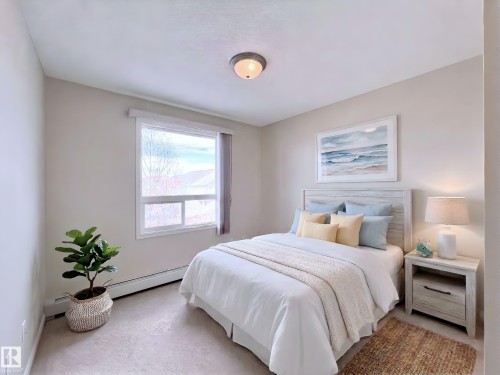 Bedroom featuring carpet floors and a baseboard heating unit - 3308 9351 Simpson Drive, Edmonton, AB - Indoor Photo Showing Bedroom