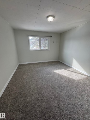 Empty room featuring baseboards and carpet floors - 4801 52 Avenue, Andrew, AB - Indoor Photo Showing Other Room