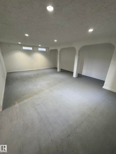Basement with recessed lighting, a textured ceiling, and arched walkways - 4801 52 Avenue, Andrew, AB - Indoor