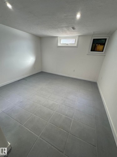 Below grade area with light tile patterned floors and a textured ceiling - 4801 52 Avenue, Andrew, AB - Indoor