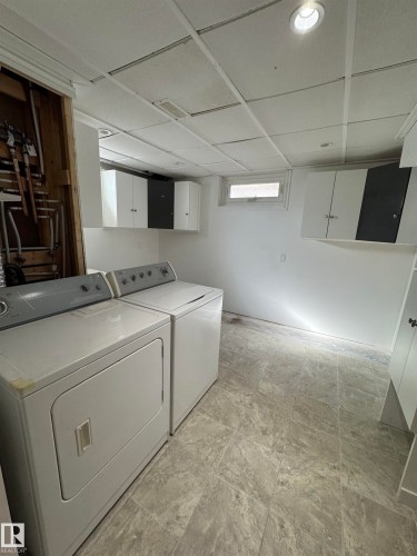 Laundry room with cabinet space and washing machine and clothes dryer - 4801 52 Avenue, Andrew, AB - Indoor Photo Showing Laundry Room