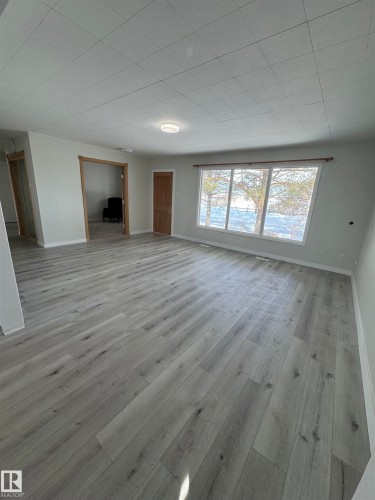 Unfurnished living room with baseboards and light wood-style flooring - 4801 52 Avenue, Andrew, AB - Indoor Photo Showing Other Room