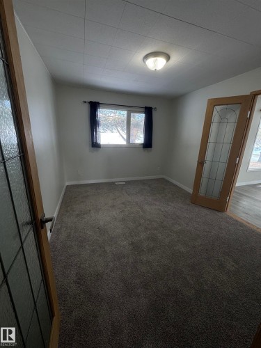 Spare room with carpet flooring and baseboards - 4801 52 Avenue, Andrew, AB - Indoor Photo Showing Other Room