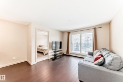 Living room featuring hardwood / wood-style flooring and a baseboard heating unit - 