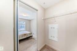 Laundry area featuring a textured ceiling and light carpet - 
