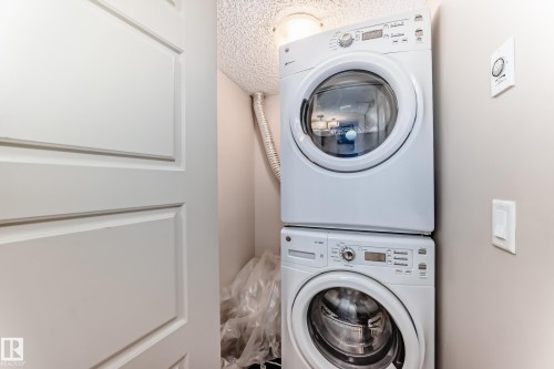 Laundry room with stacked washing machine and dryer - 229 6076 Schonsee Way, Edmonton, AB - Indoor Photo Showing Laundry Room
