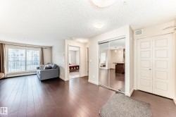 Entryway featuring a textured ceiling, wood finished floors, and a baseboard heating unit - 