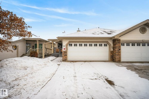 Ranch-style house with a deck, a garage, and stone siding - 30 4 Heritage Way, St. Albert, AB - Outdoor