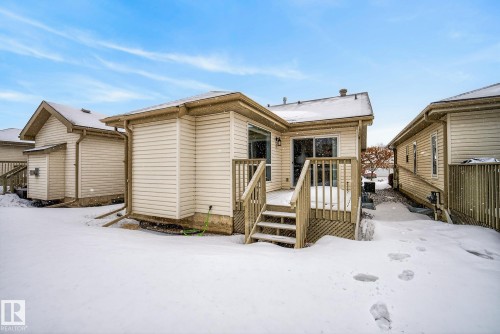 Snow covered back of property featuring a deck - 30 4 Heritage Way, St. Albert, AB - Outdoor