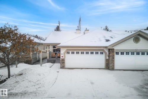 Ranch-style home with a chimney, stone siding, a garage, and a wooden deck - 30 4 Heritage Way, St. Albert, AB - Outdoor