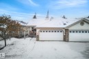 Ranch-style home with a chimney, stone siding, a garage, and a wooden deck - 30 4 Heritage Way, St. Albert, AB  - Outdoor 