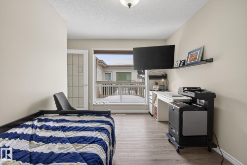 Bedroom with light wood-style floors and a textured ceiling - 30 4 Heritage Way, St. Albert, AB - Indoor Photo Showing Bedroom