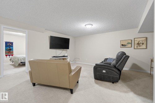 Living room with a textured ceiling and light carpet - 30 4 Heritage Way, St. Albert, AB - Indoor