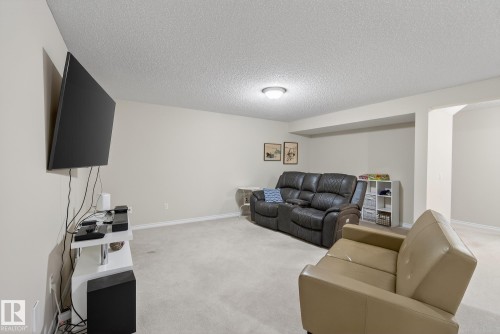Living area featuring a textured ceiling and light carpet - 30 4 Heritage Way, St. Albert, AB - Indoor Photo Showing Living Room