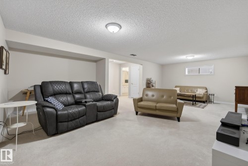 Carpeted living room featuring a textured ceiling and baseboards - 30 4 Heritage Way, St. Albert, AB - Indoor Photo Showing Living Room