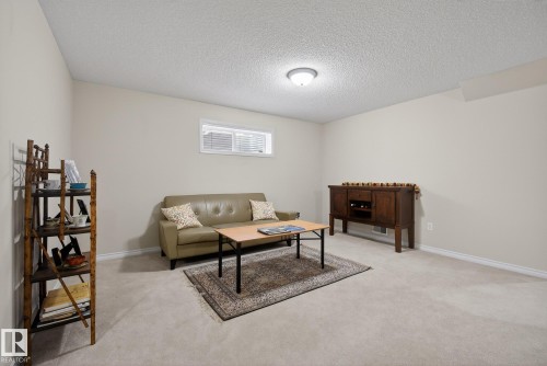 Living area with light colored carpet and a textured ceiling - 30 4 Heritage Way, St. Albert, AB - Indoor