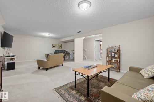 Living room with a textured ceiling and light colored carpet - 30 4 Heritage Way, St. Albert, AB - Indoor Photo Showing Other Room