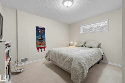 Bedroom featuring a textured ceiling and light colored carpet - 30 4 Heritage Way, St. Albert, AB - Indoor Photo Showing Bedroom